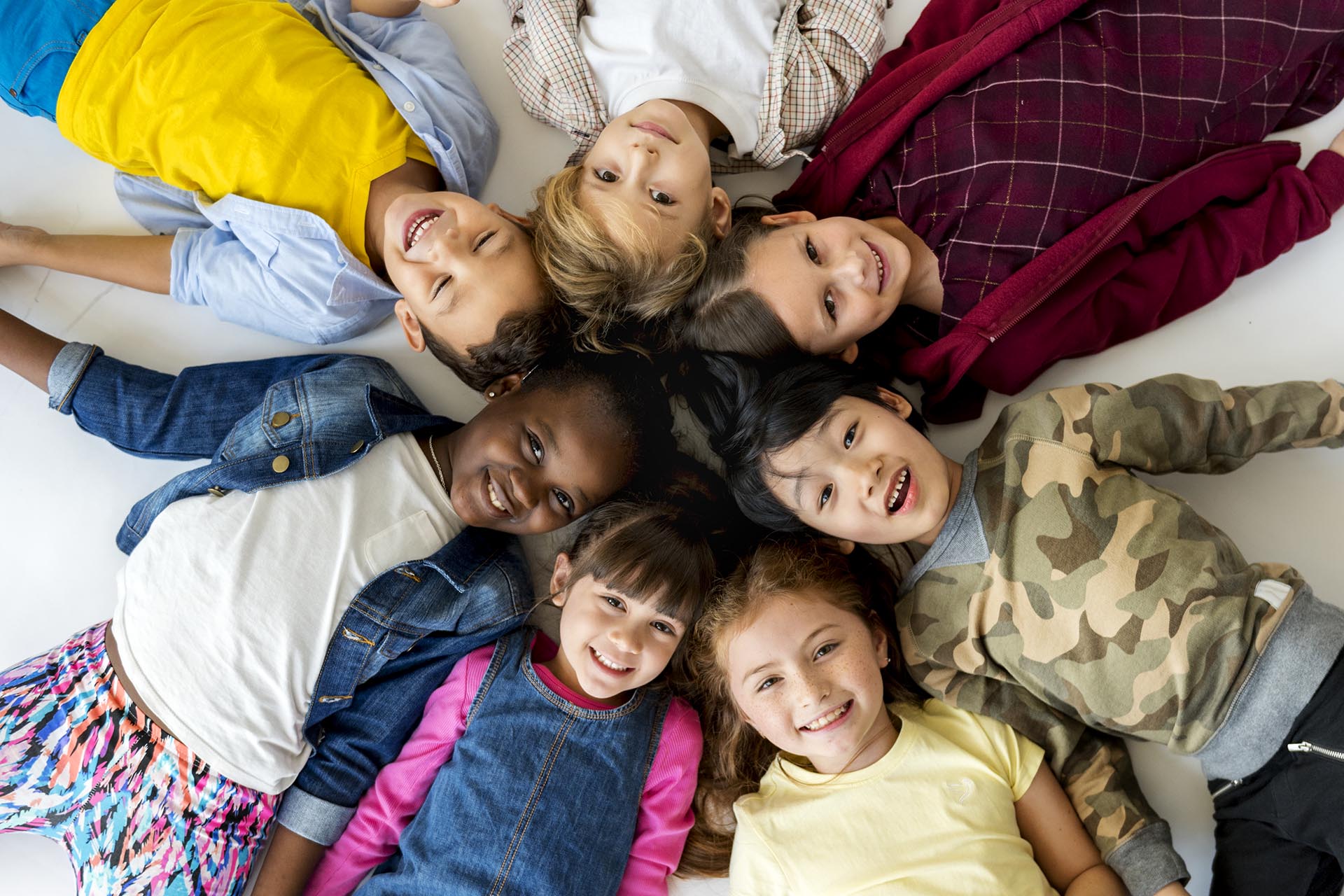 A group of primary schoolers lying on the ground and smiling